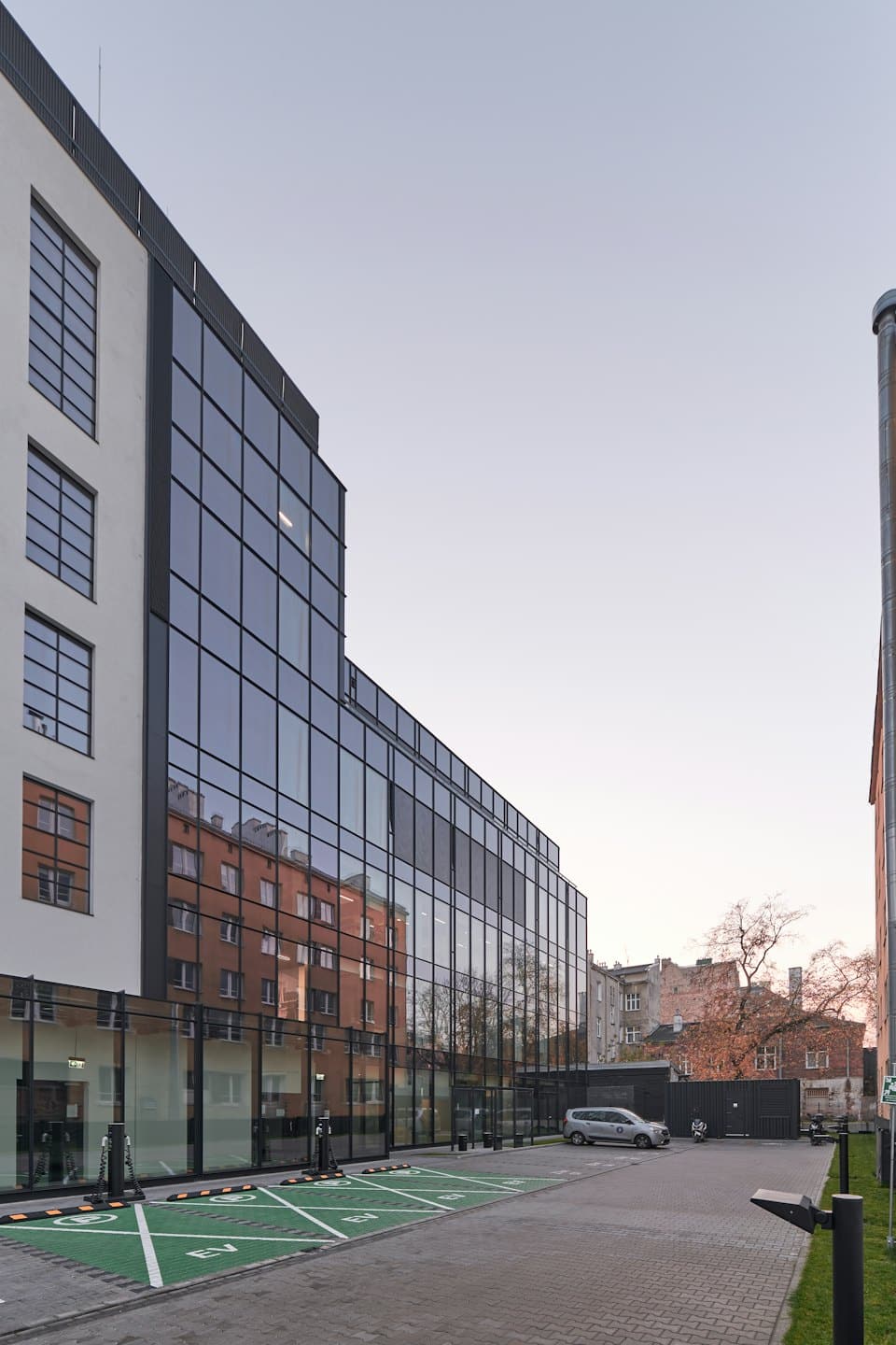 Moderno edificio per uffici con stazioni di ricarica nel parcheggio.
